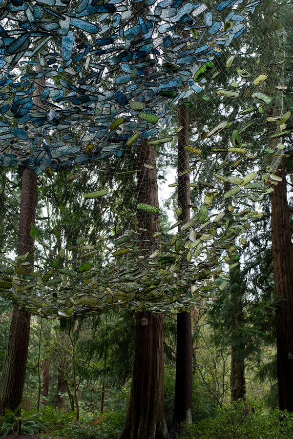Circular art installation made of blue and green glass bottles.