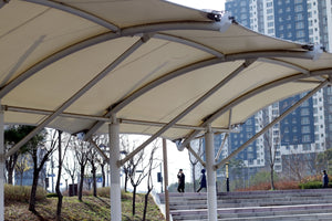 Modern canopy structure with buildings in background